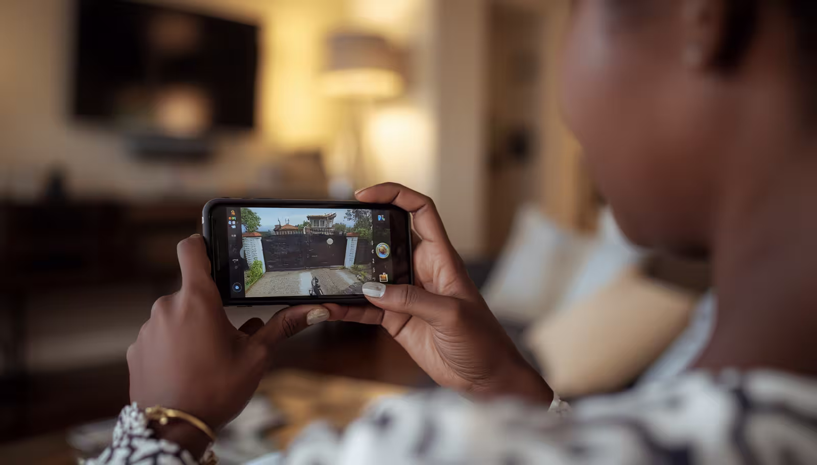 Ugandan homeowner monitoring home security cameras remotely on a smartphone using Easy Power CCTV system
