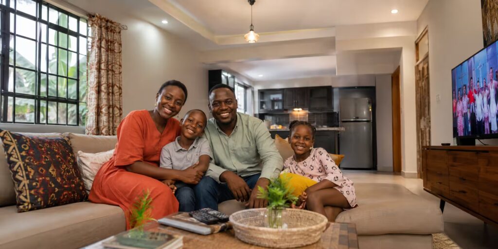 Ugandan family enjoying solar-powered electricity at home in Kampala with lights TV and fridge all running on solar energy